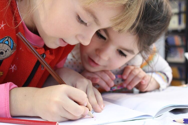 Two children working in a workbook.